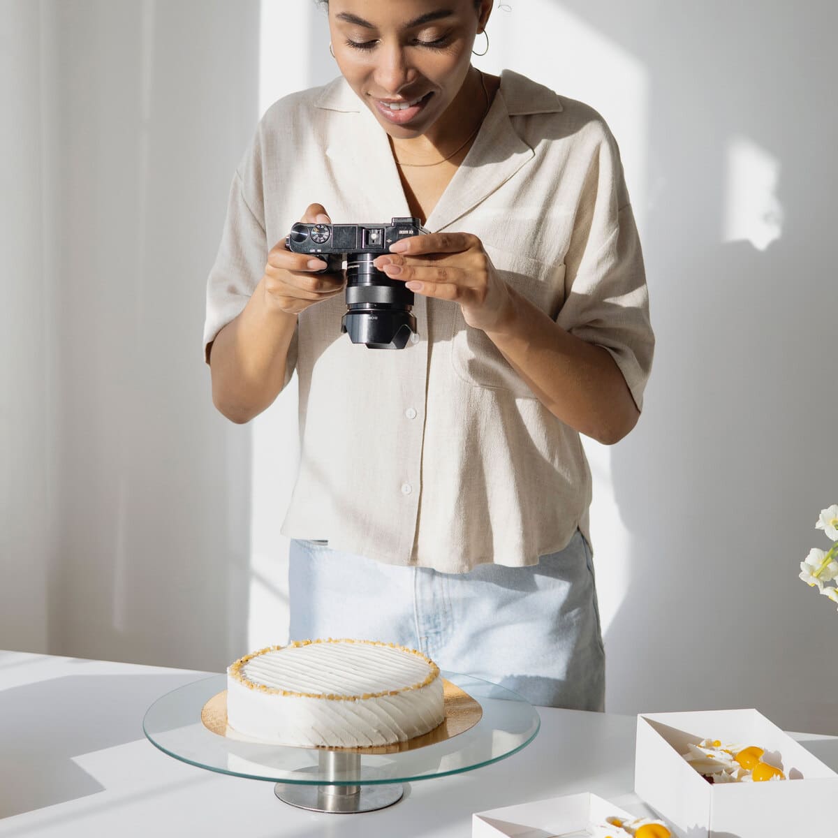 Chica haciendo una fotografía a una tarta para una pastelería de reparto a domicilio